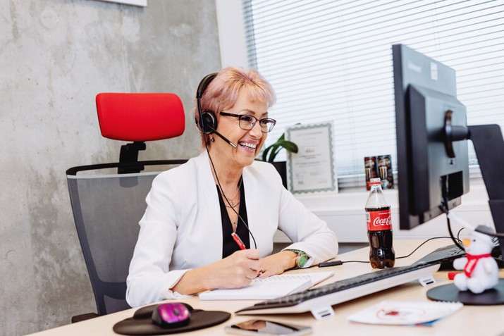 Frau mit Headset vor Computer