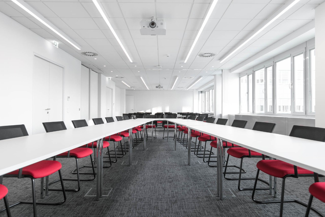 Large meeting room with long tables and over 30 chairs