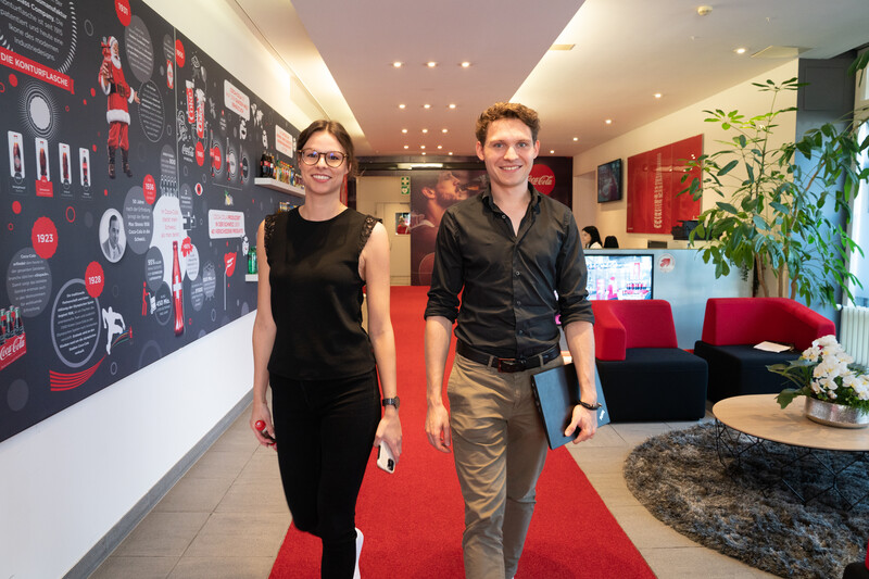 Young woman and young man walking through a Coca-Cola HBC office